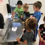 Children standing around a sink