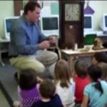 man explains clock to class of children