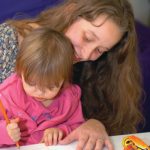 parent helps child draw