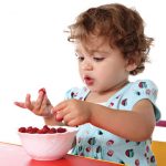child eats food from bowl