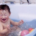 baby in bath with toys