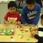 children at table building with blocks