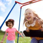 two young girls on swingset