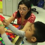 teacher showing child toy letters
