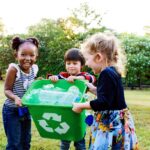 Children holding a recycling bin