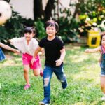 Children running around playing soccer