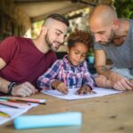 two dads with child drawing